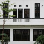 Minimalist white and black Asian-style building with elegant green trees